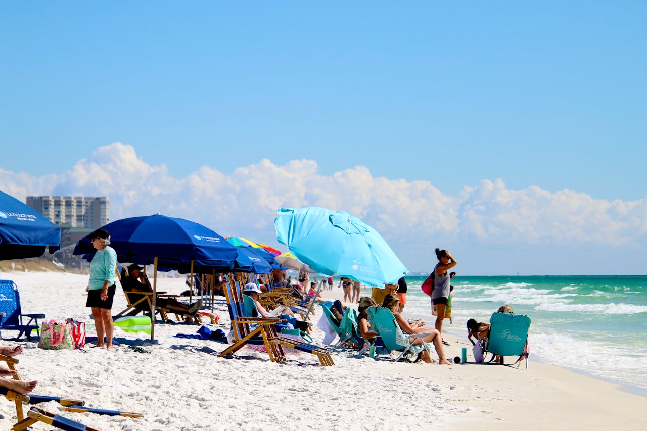 get-in-touch Vibrant beach scene with umbrellas and people enjoying a sunny summer day by the sea.